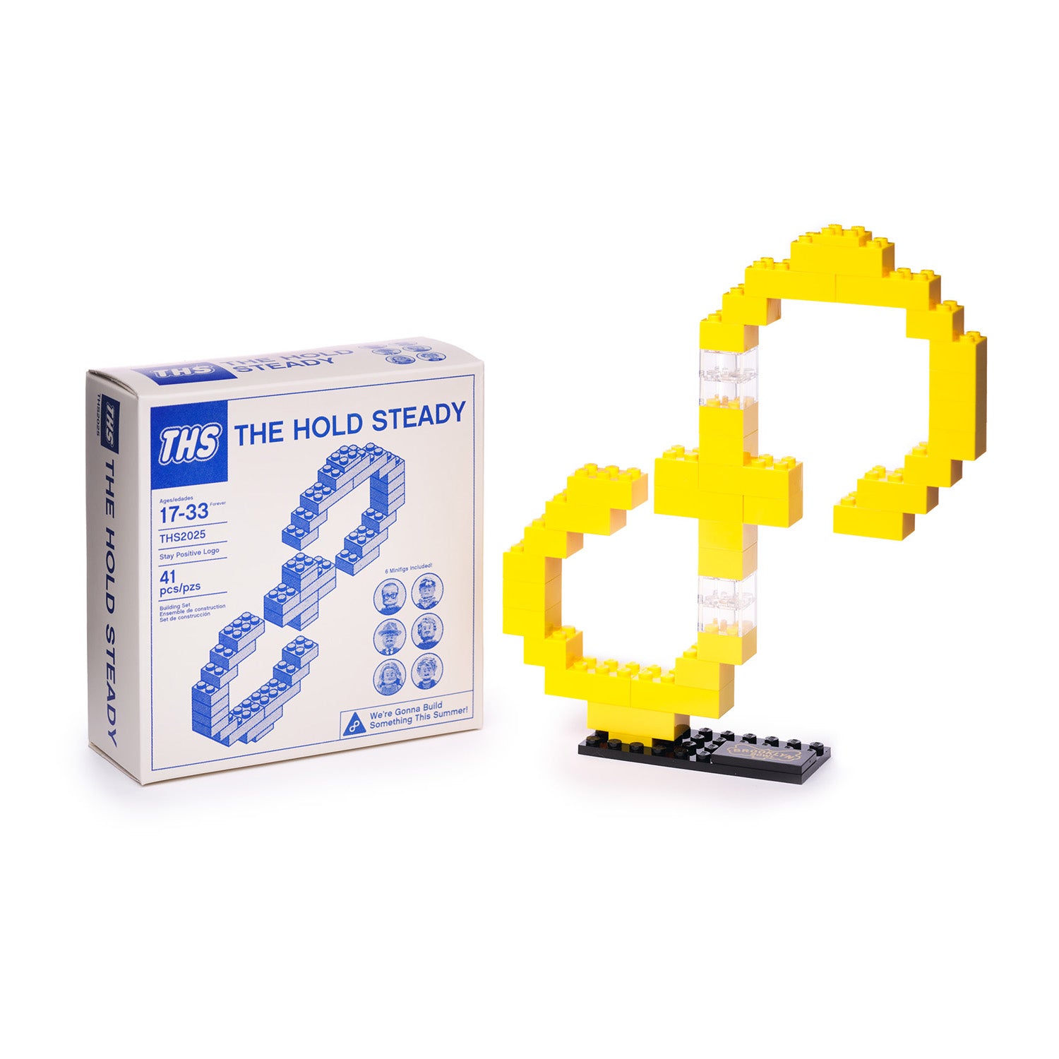 A collectible brick-building kit from The Hold Steady featuring a yellow infinity symbol on a black base—a perfect souvenir from Massive Nights 10 at Brooklyn Bowl. Box labeled “THE HOLD STEADY.”.